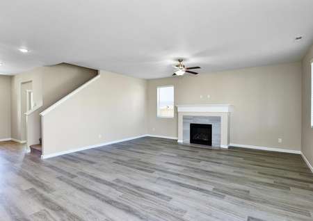 Spacious family room with a ceiling fan and plank flooring