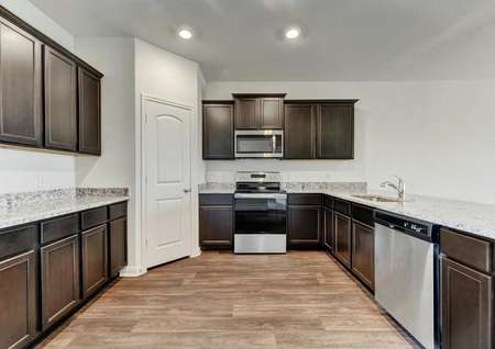 Travis kitchen with stainless steel appliances, granite countertops and wood-look flooring