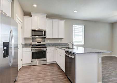 The Crystal floor plan kitchen with wood-like floors, stainless steel appliances and granite countertops.