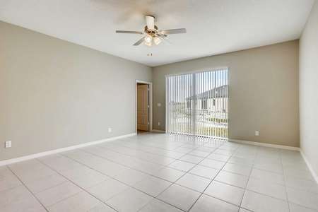 The spacious living room in the Patricio model home. Tile flooring, ceiling fan, back sliding door