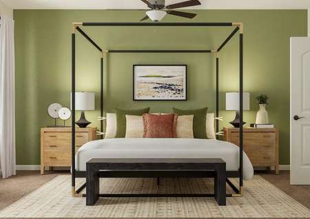 Rendering of the spacious master suite in
  the Roanoke floor plan. The room has a window and ceiling fan and is
  decorated with a poster bed, two nightstands, a bench at the end of the bed
  and a rug.