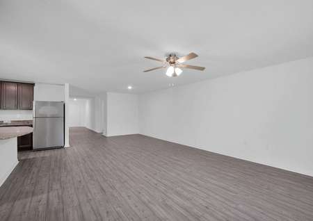 Sizable family room with a ceiling fan and luxury vinyl plank flooring.