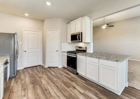 The kitchen offers beautiful, white cabinetry and granite countertops.