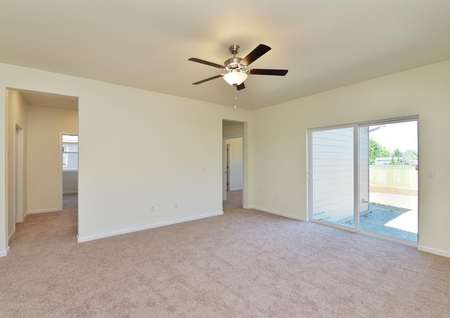 Living room with carpet and ceiling fan and sliding glass door to back yard.