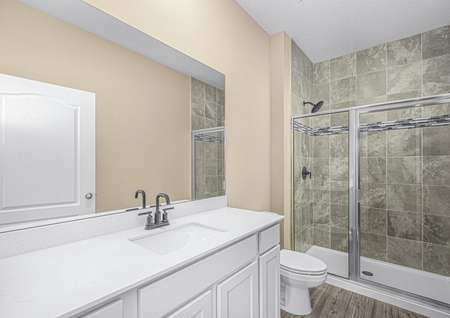 The master bathroom has a large vanity and step-in shower