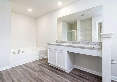 Master bathroom with white cabinets, a single sink vanity, and garden tub.