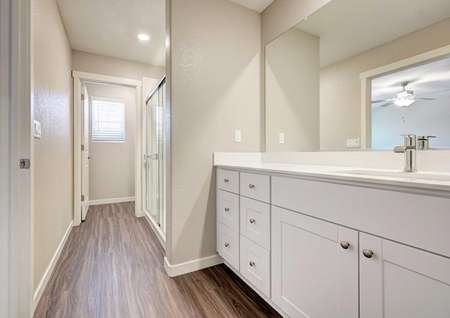 The Kennedy floor plan's master bathroom with a walk-in shower, cultured marble countertops and wood-like floors.