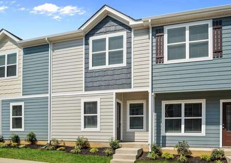 The Pine plan has tan siding with a dark blue shake siding accent.