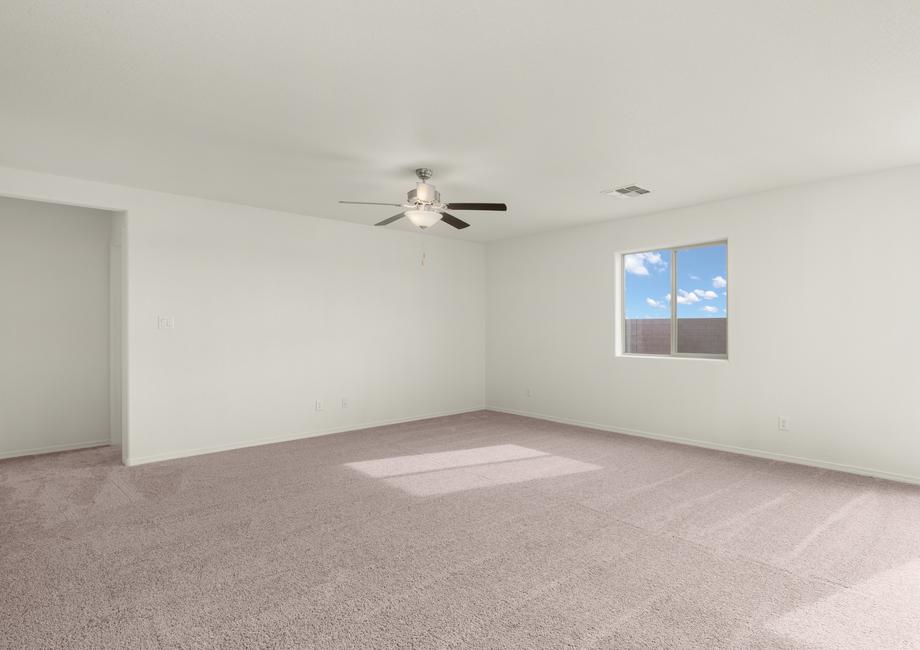 Spacious family room with large windows and a ceiling fan.
