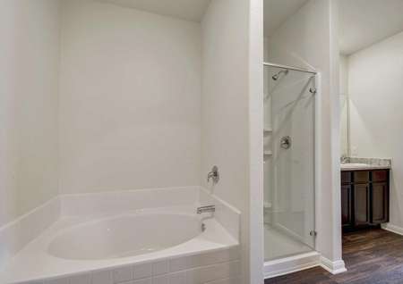 Driftwood bathroom with shower stall, modern white bathtub, and granite countertops