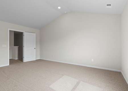 Master bedroom with tan walls and carpet.