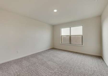 The master suite has brown carpet and light walls.
