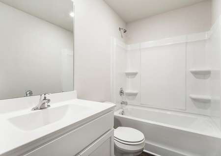 Secondary bathroom with a large vanity, white cabinets and a shower and tub combo.