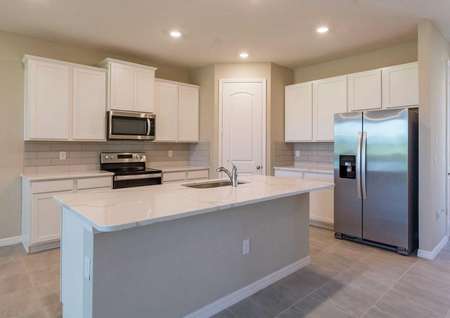 The Sorrento floor plan kitchen has tile flooring, recessed lighting, quartz countertops and islands with a sink.
