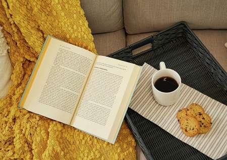 Trace home plan with open book, coffee mug, and cookies