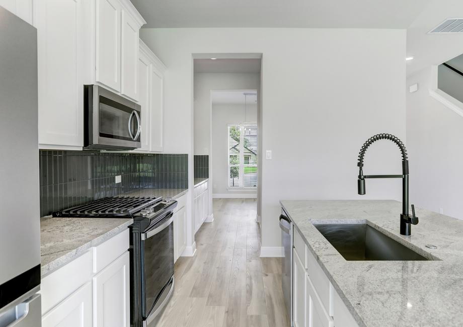 Stunning kitchen with a tile backsplash, granite countertops, and a full suite of stainless appliances.