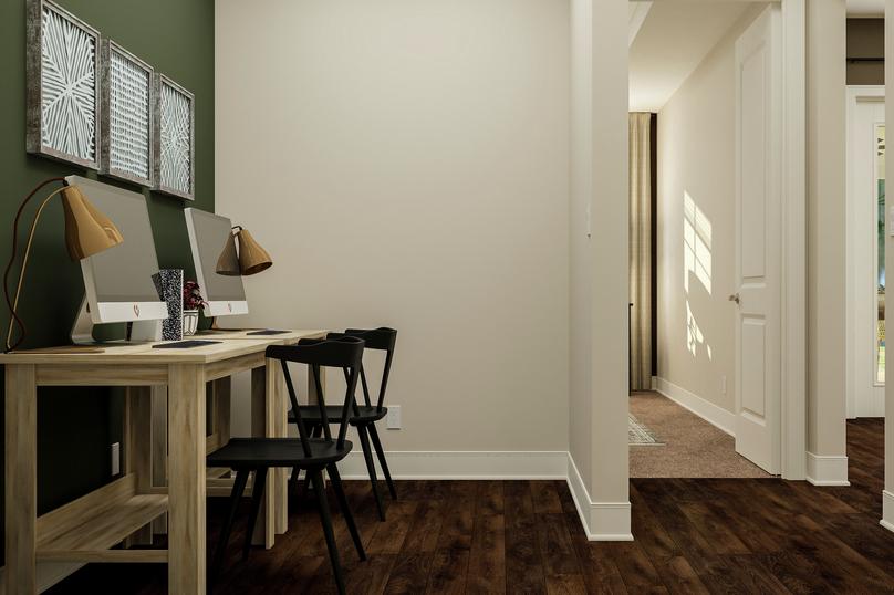 Rendering of tech nook showing two desks
  and chairs along a green accent wall and view of the hallway with dark wood
  look flooring throughout.
