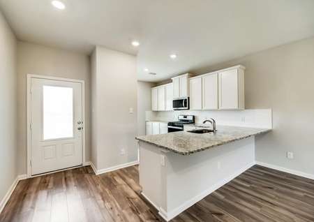The kitchen has stunning, white cabinetry and granite countertops.