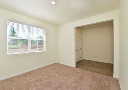 The spacious flex room off the foyer of this home is carpeted and has a large window looking out to the front yard.