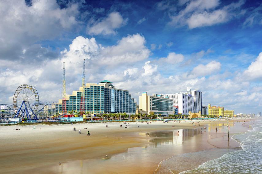 Daytona Beach, Florida beach front featuring hotels and condos, amusement park, and wet sand from the tide