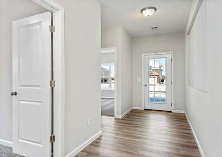 View from foyer to full lite front door and hallway leading to front bedrooms, 