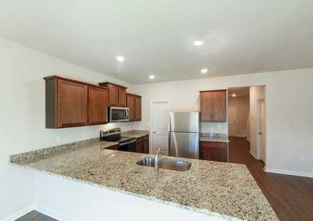 Open-concept floor plan featuring stainless steel appliances and granite countertops in the kitchen.