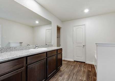 Rio bathroom with dark wood like ceramic flooring, overhead recessed light, and large vanity counter