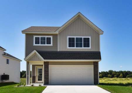 Photo of the front exterior of the St Henry Premium Elevation with tan and taupe siding, a 2-car garage and green grass.